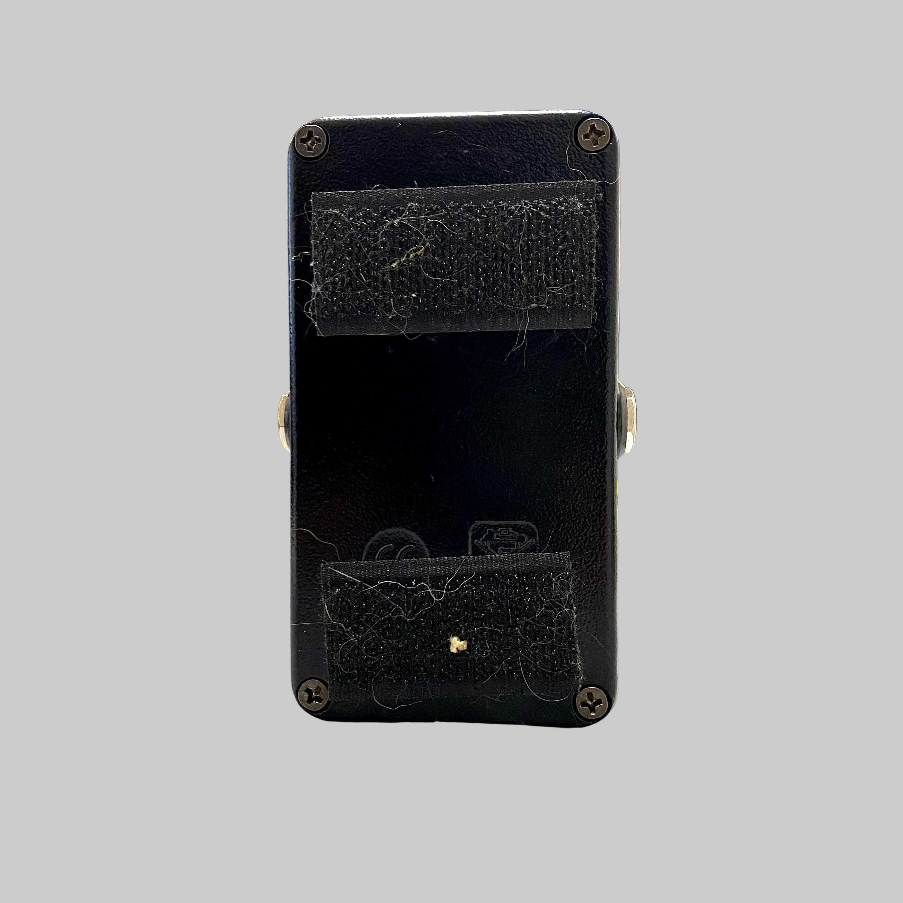 Black rectangular device with a textured surface on a light-colored floor.