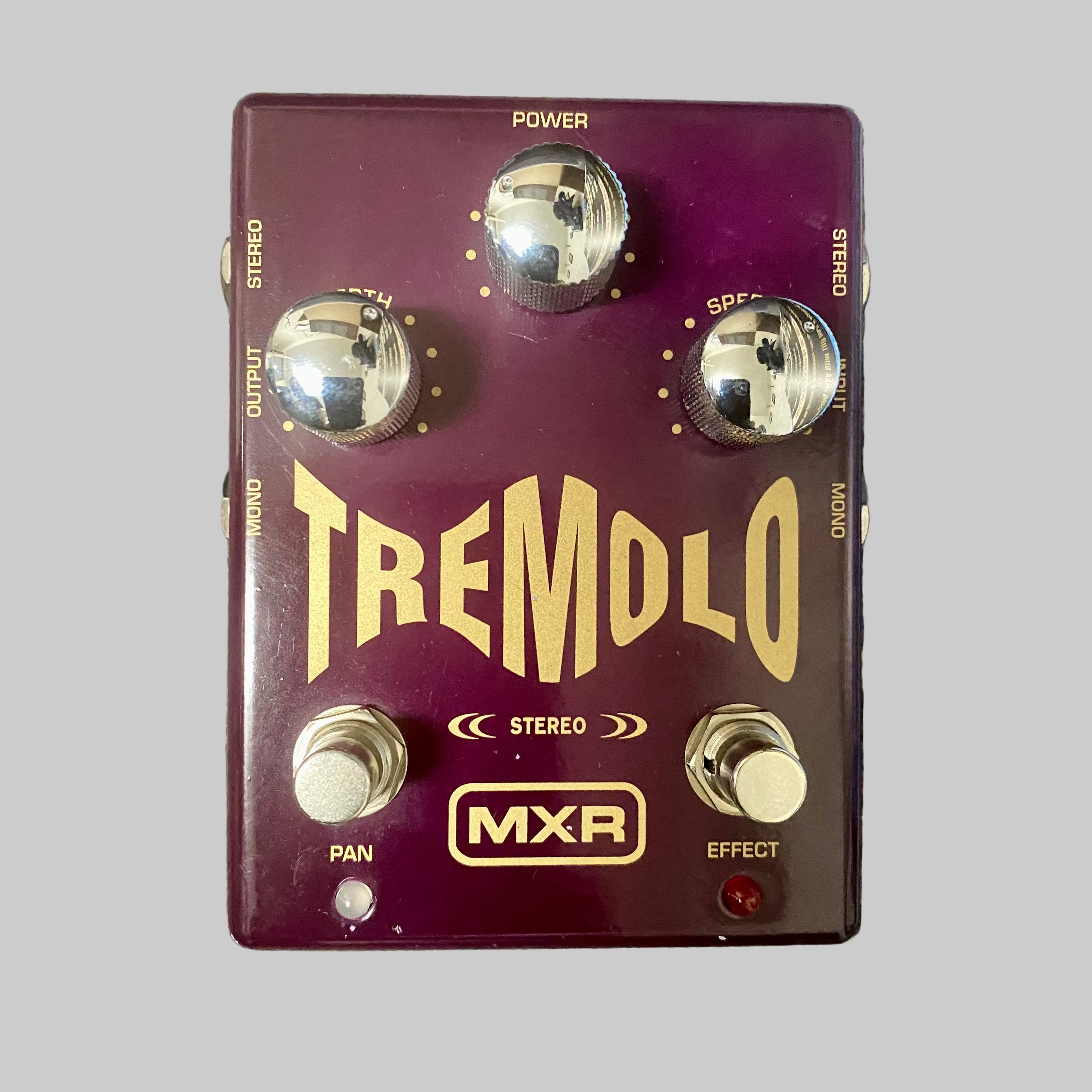 Guitar effects pedal with 'Tremolo' and 'MXR' branding on a textured surface