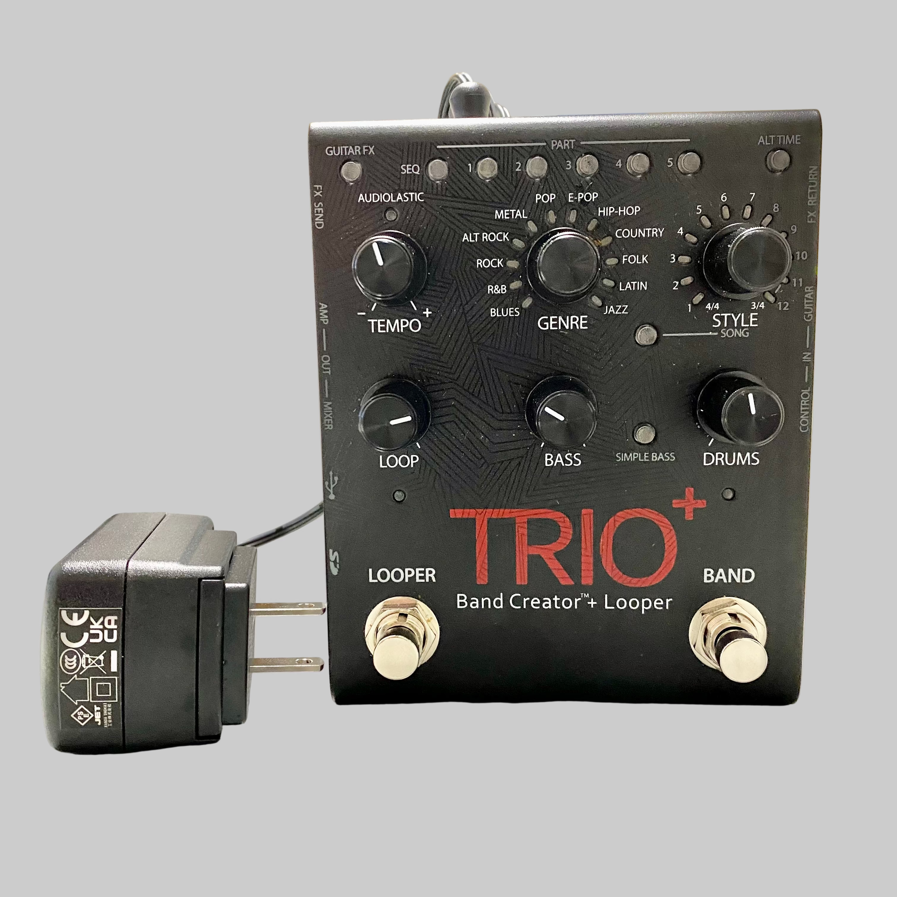 Guitar effects pedal with 'TRIO+' branding on a table