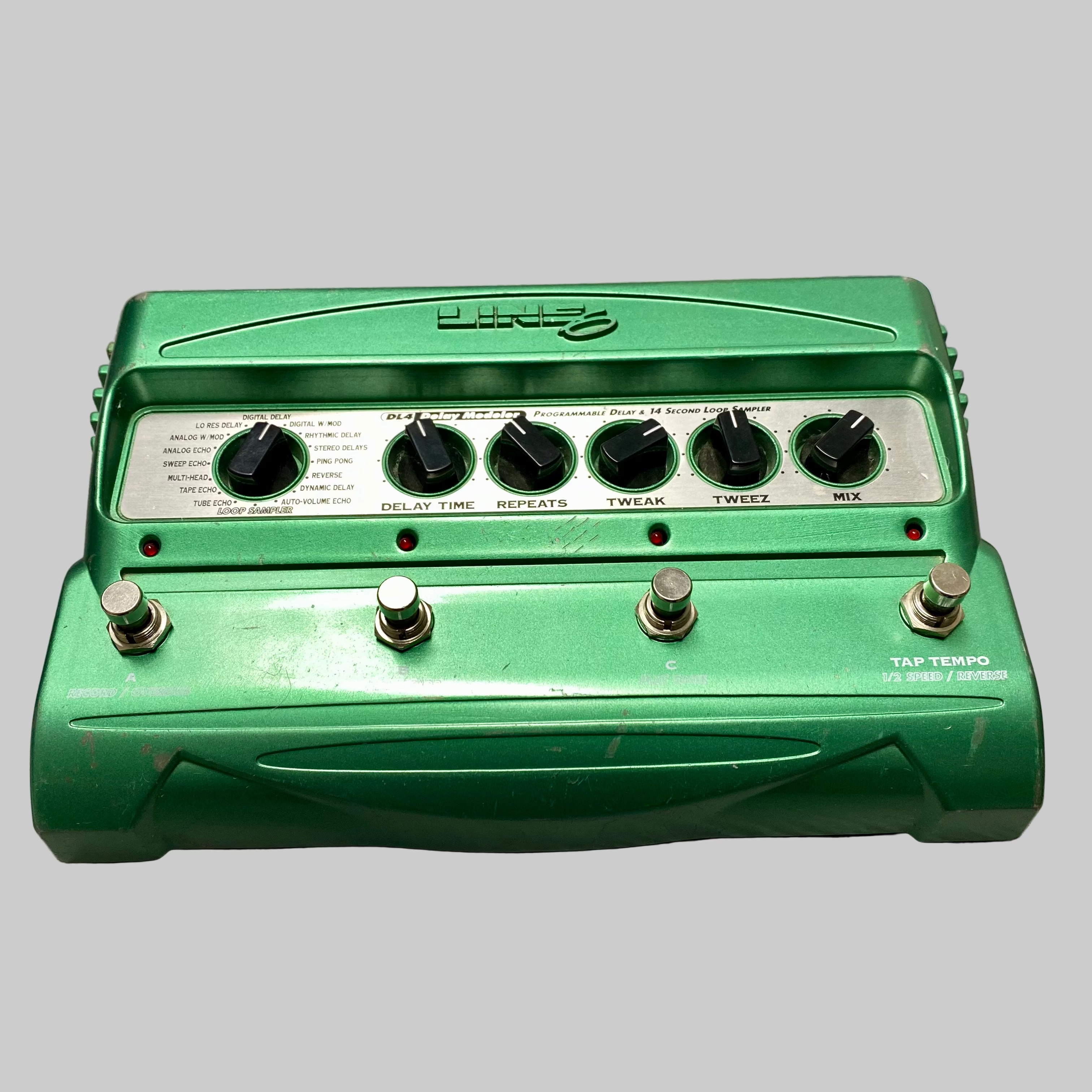 Green guitar effects pedal on a wooden surface