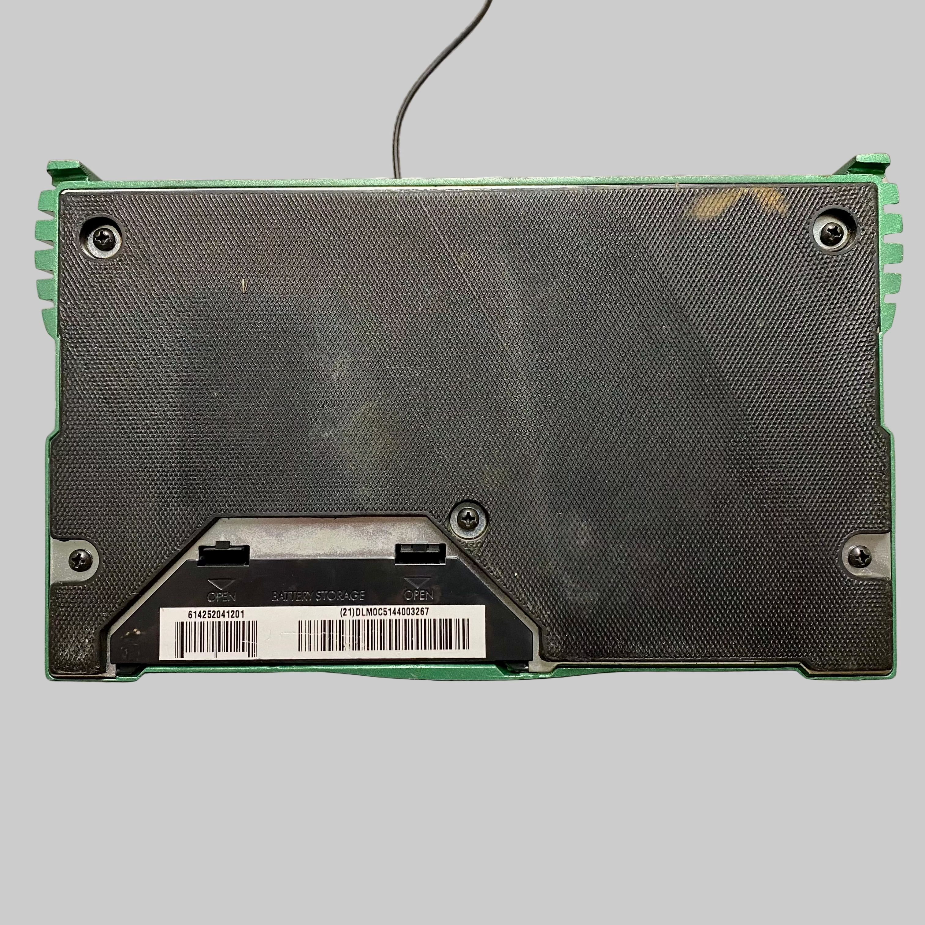 Back view of a green and black electronic device on a gray surface