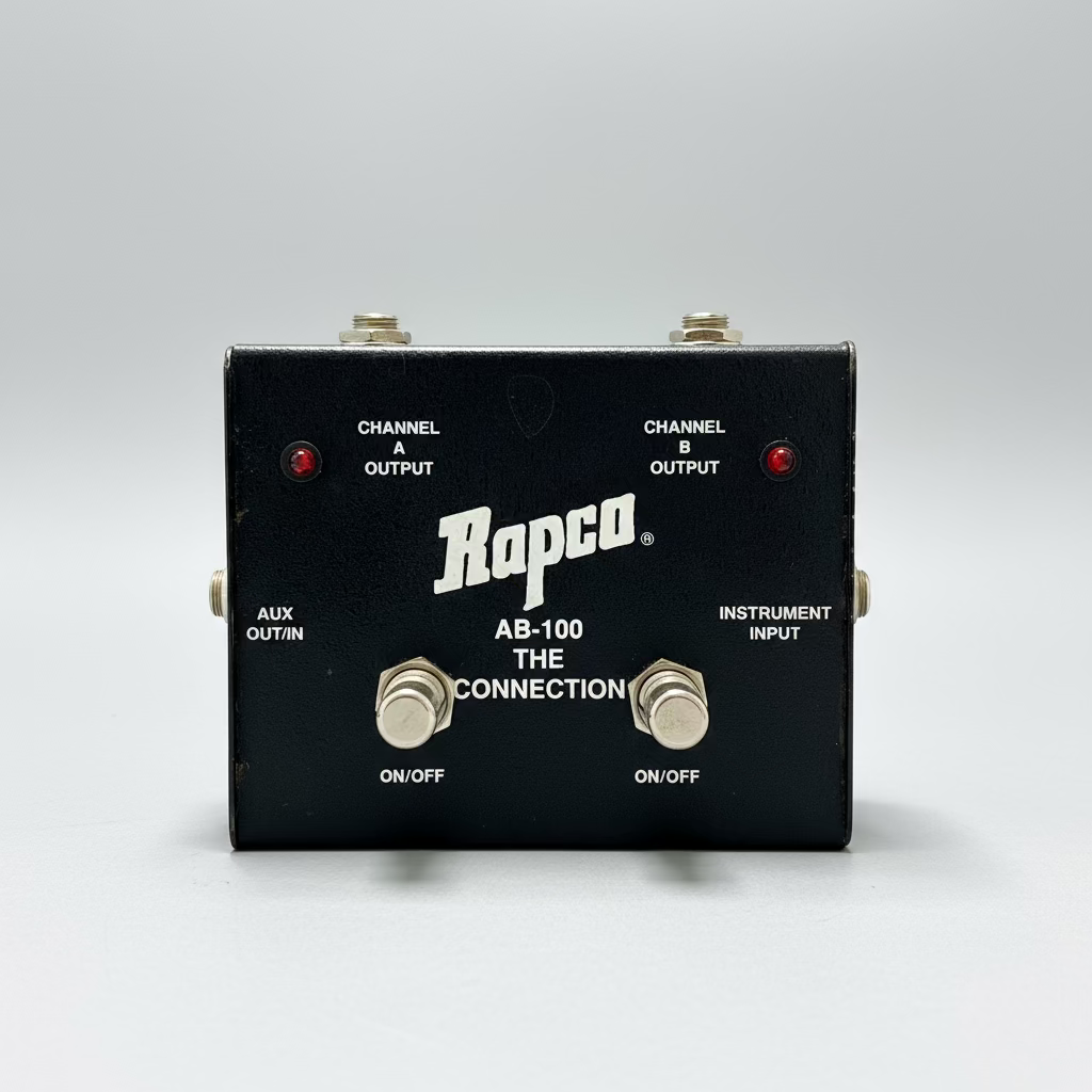 Rapco AB-100 guitar effects pedal on a wooden surface with a blurred background