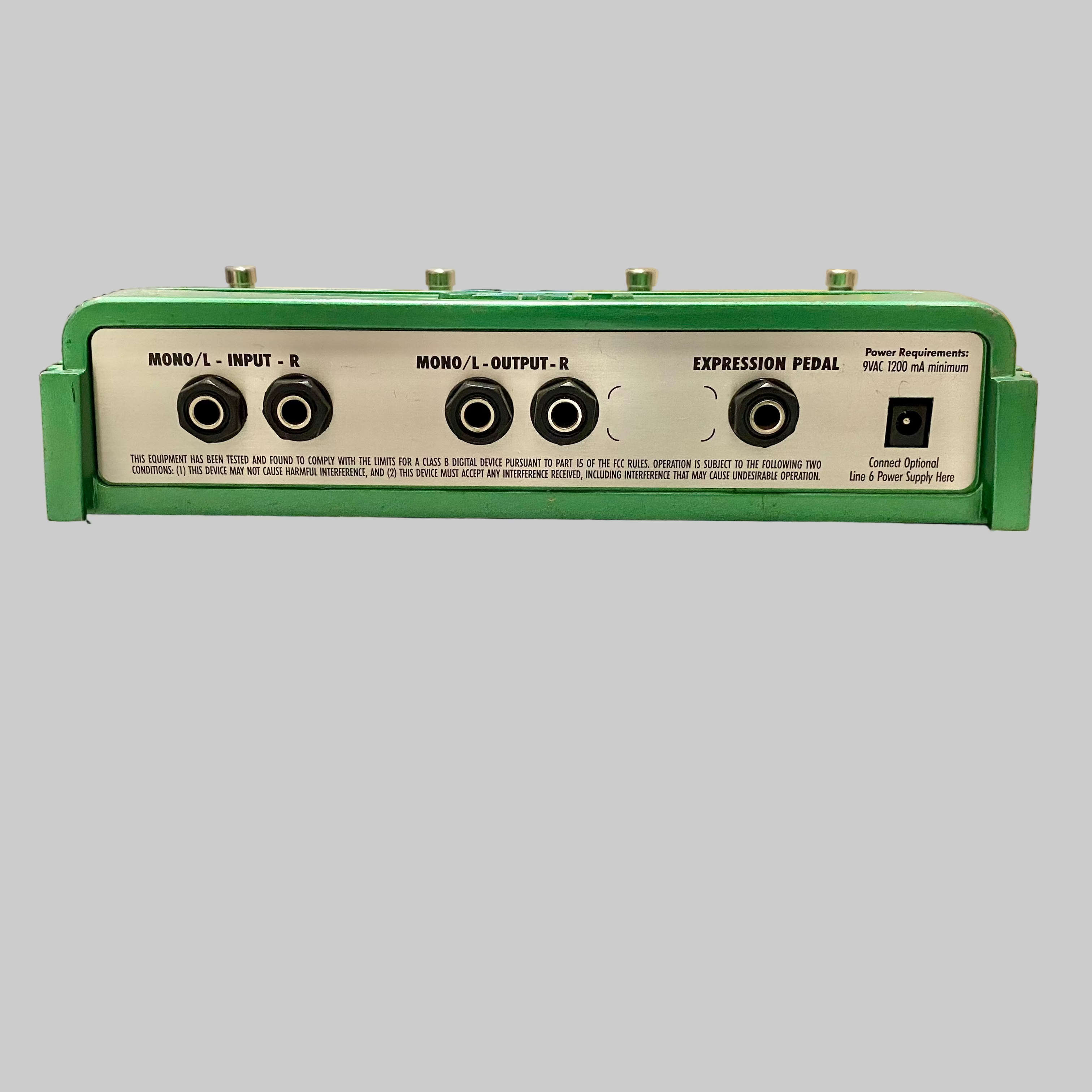 Green expression pedal on a wooden surface with a blurred background