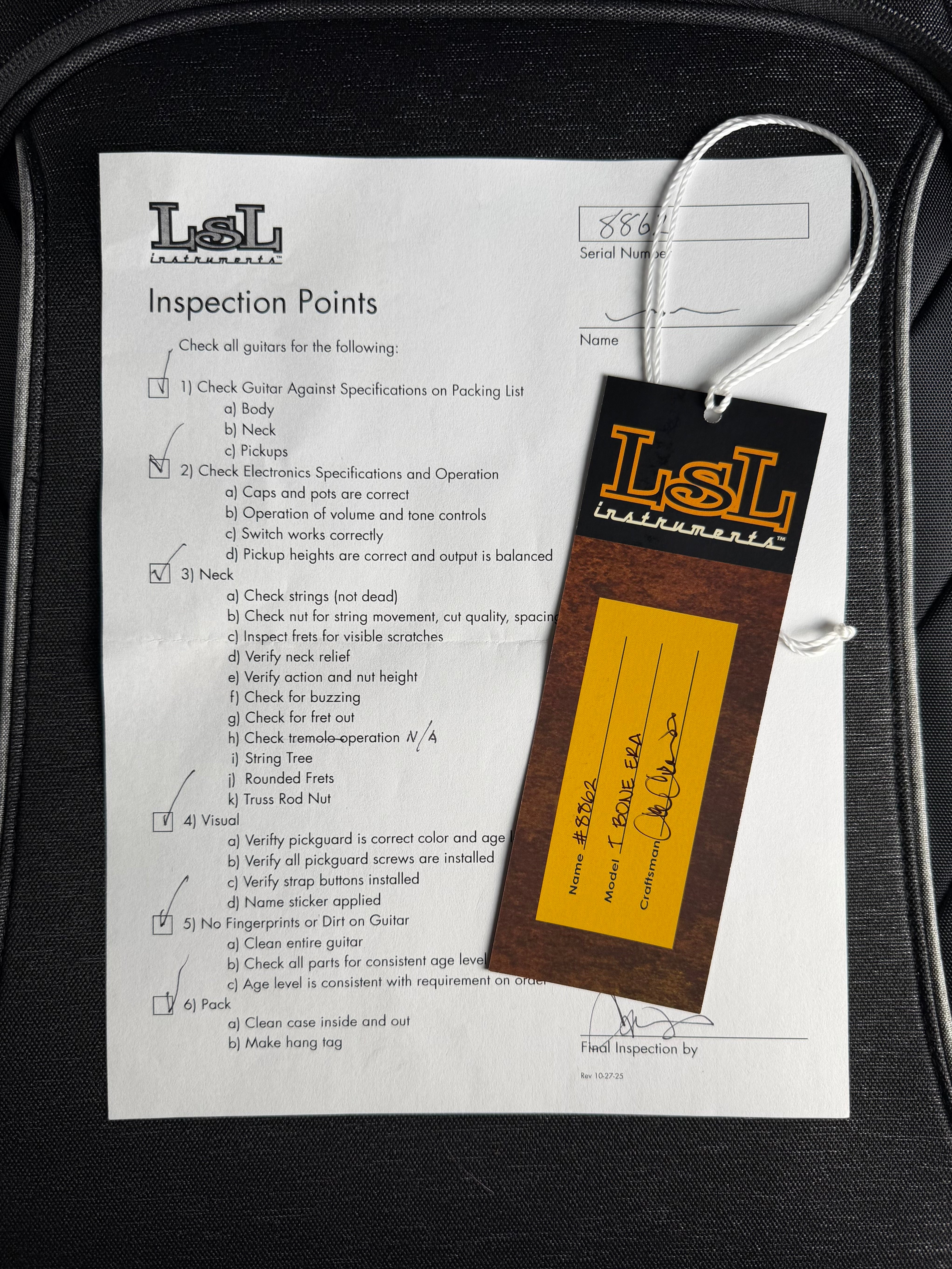 Inspection checklist and LSL branded tag on a guitar case