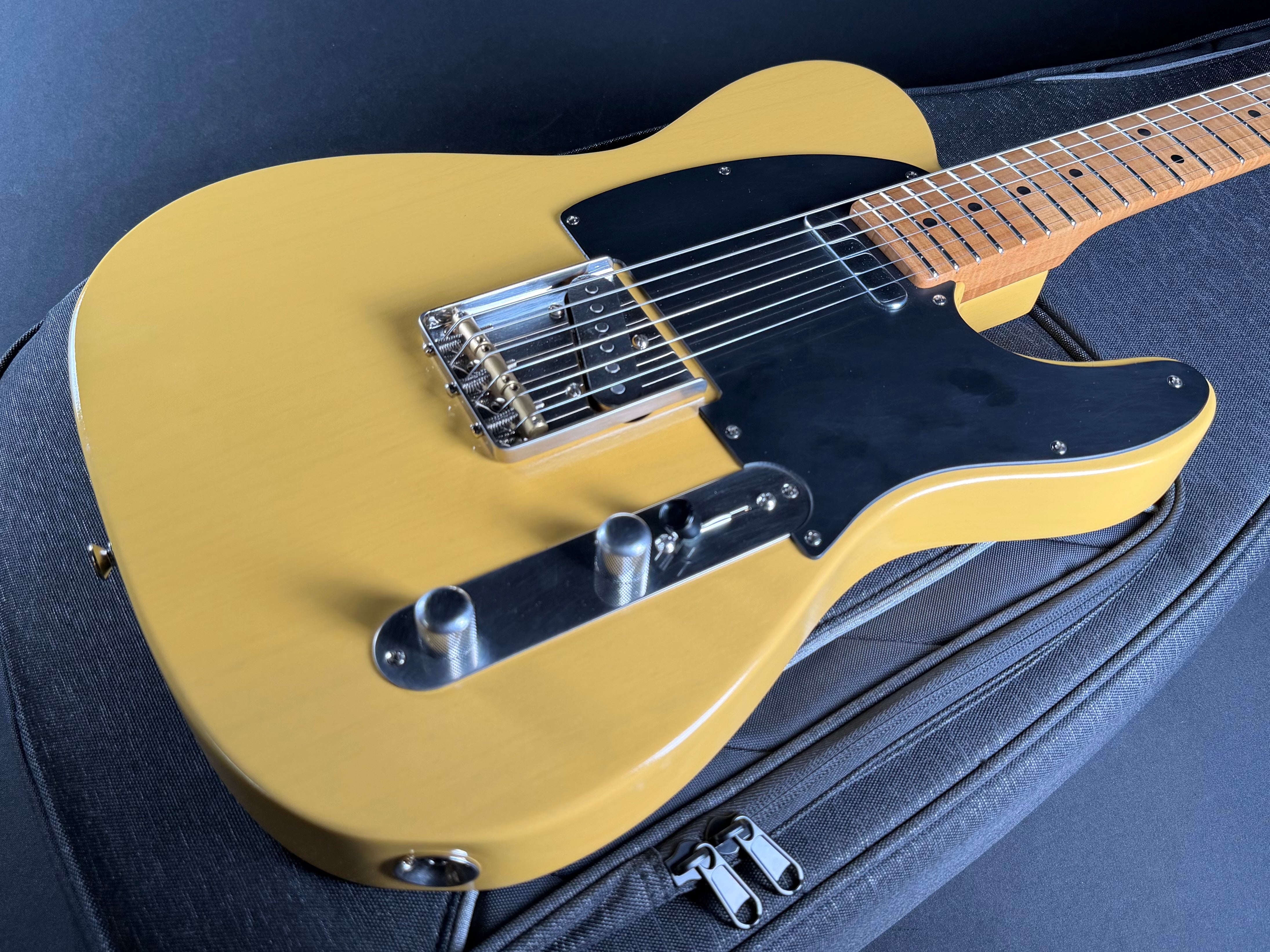 Butterscotch electric guitar on a black background