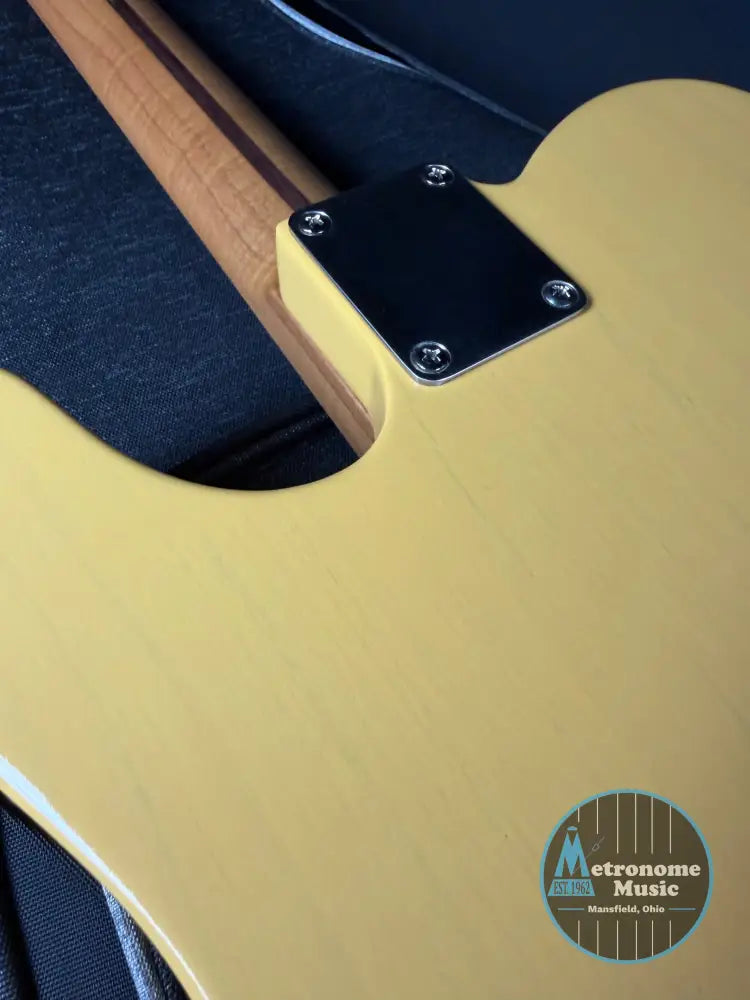Close-up of a guitar with a focus on the body and neck joint.