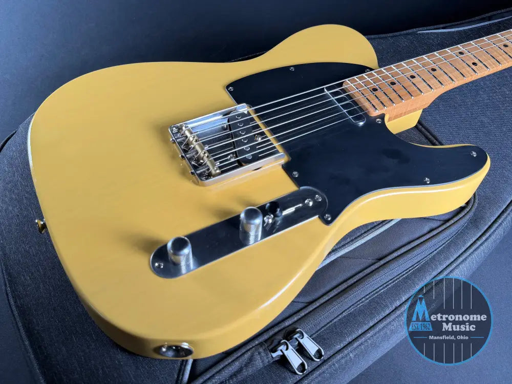 Butterscotch electric guitar on a black background