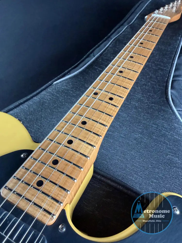 Close-up of a guitar neck and body against a blue case background