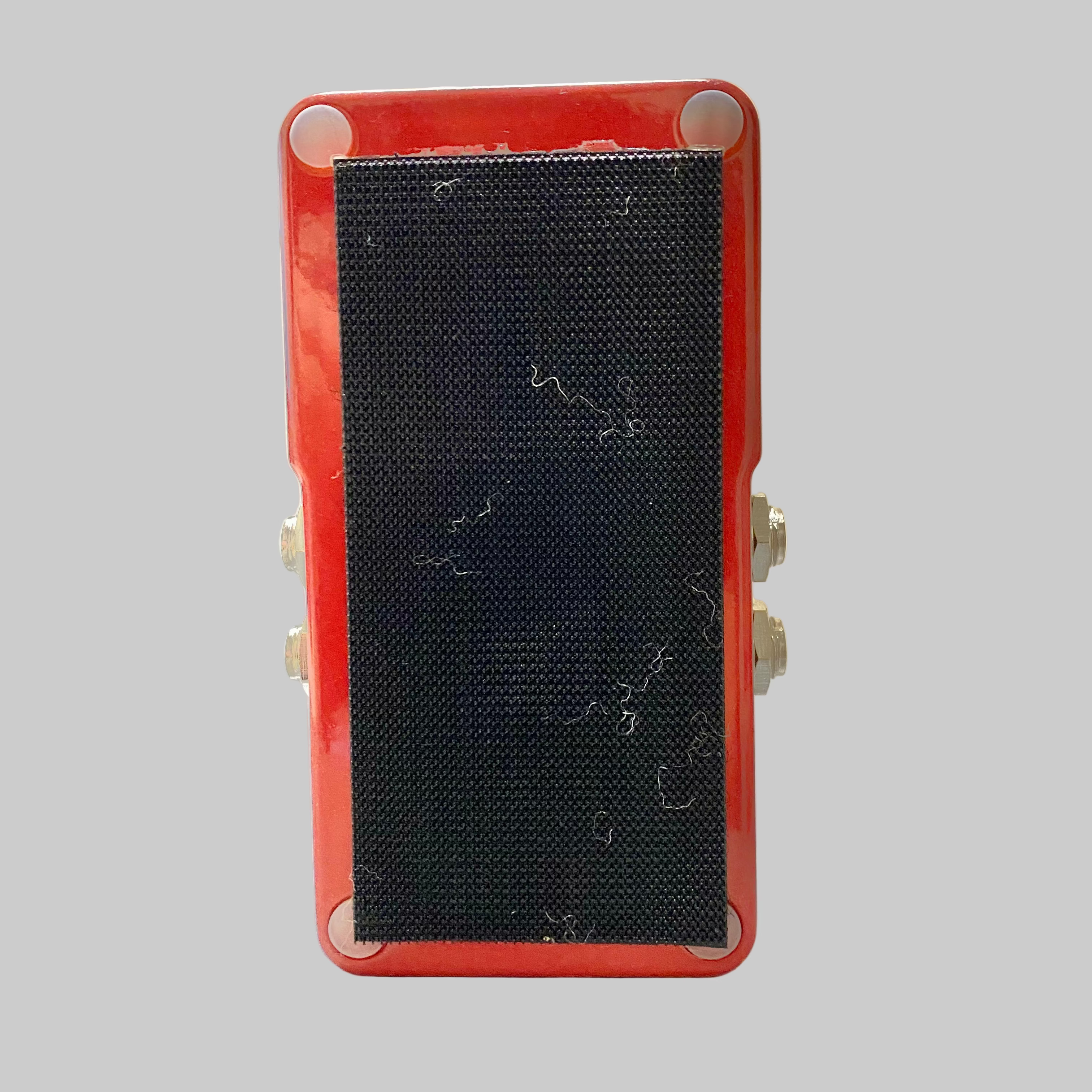 Red electronic device with a black mesh cover on a table