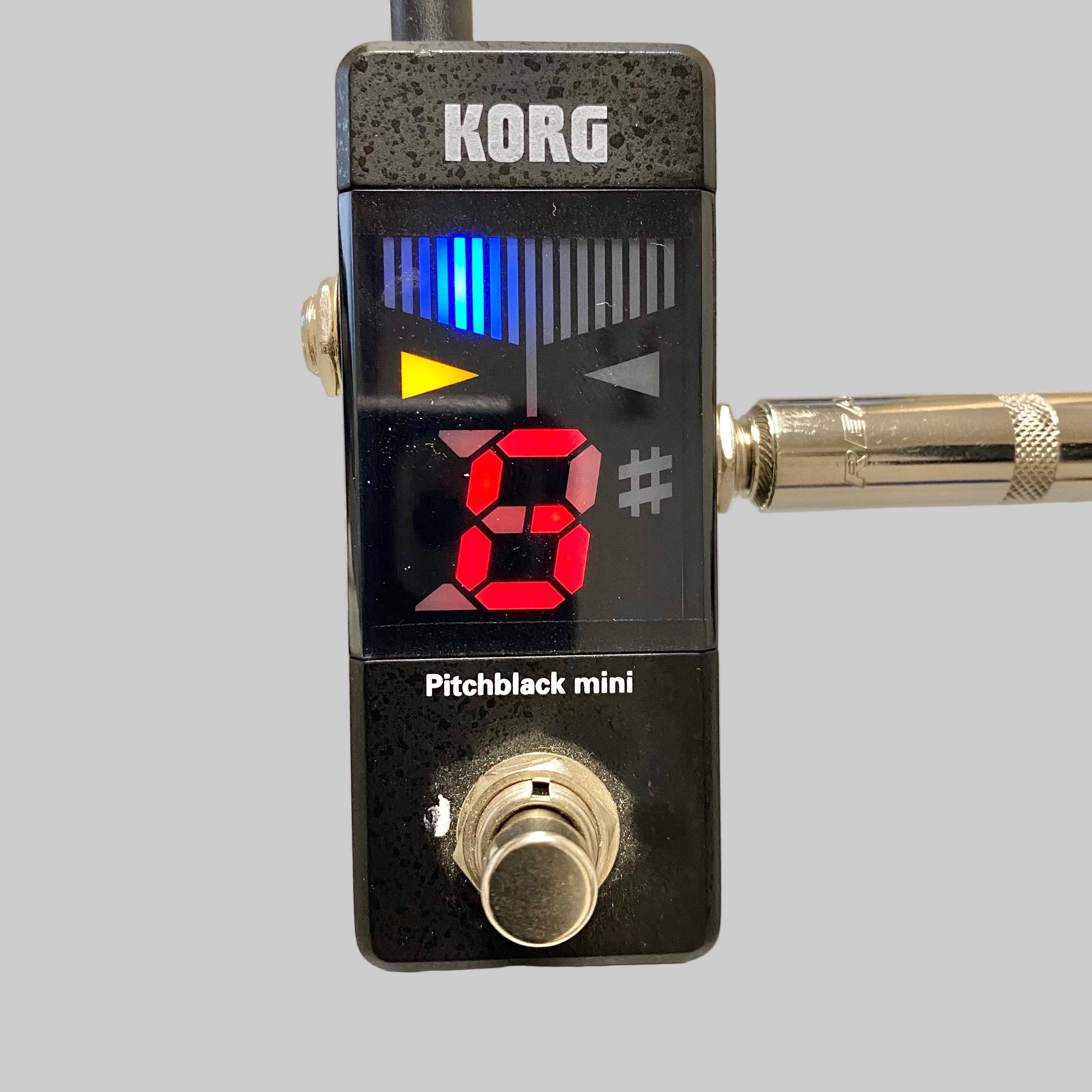 Korg Pitchblack mini guitar pedal on a gray surface
