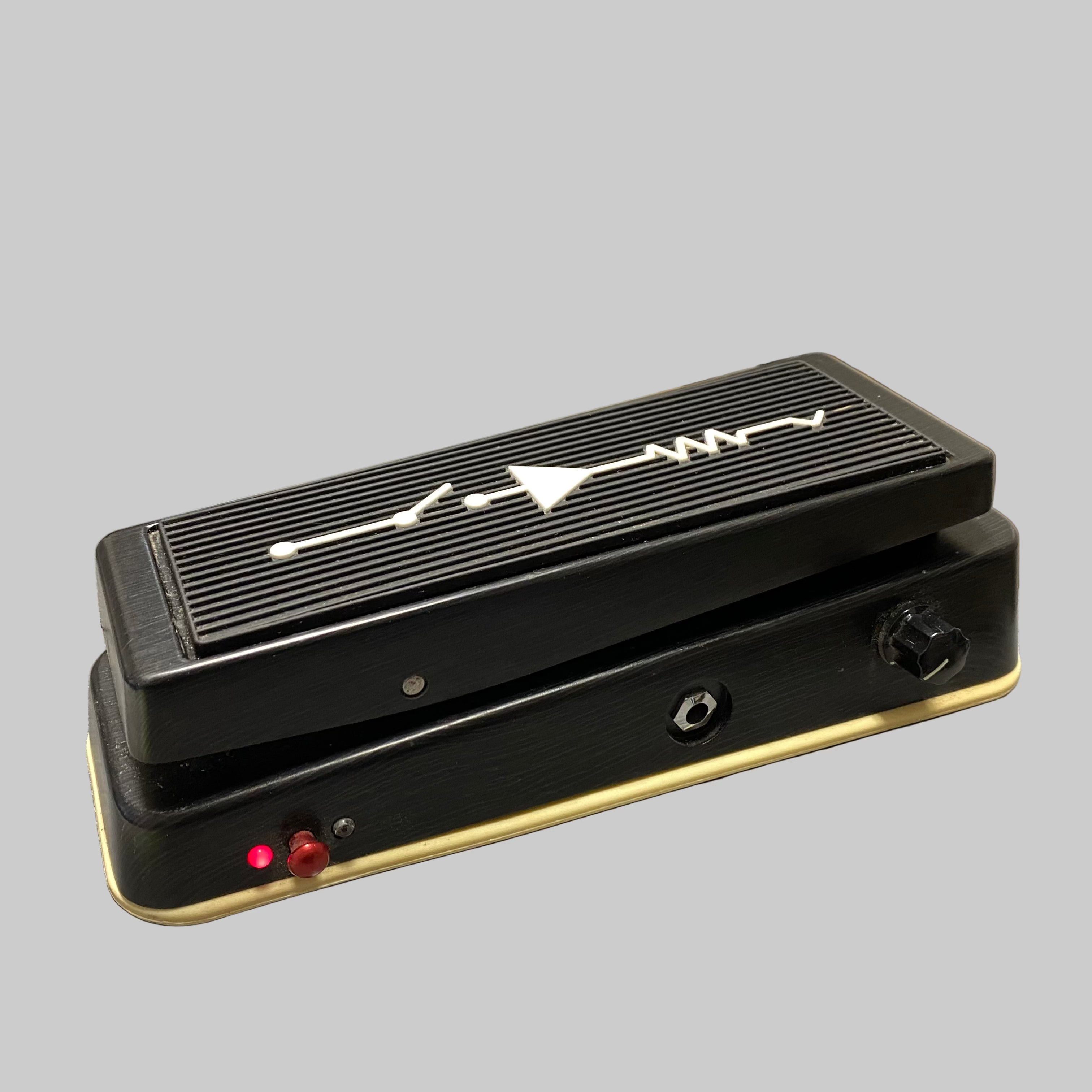 Black guitar pedal with a brand logo on a gray surface