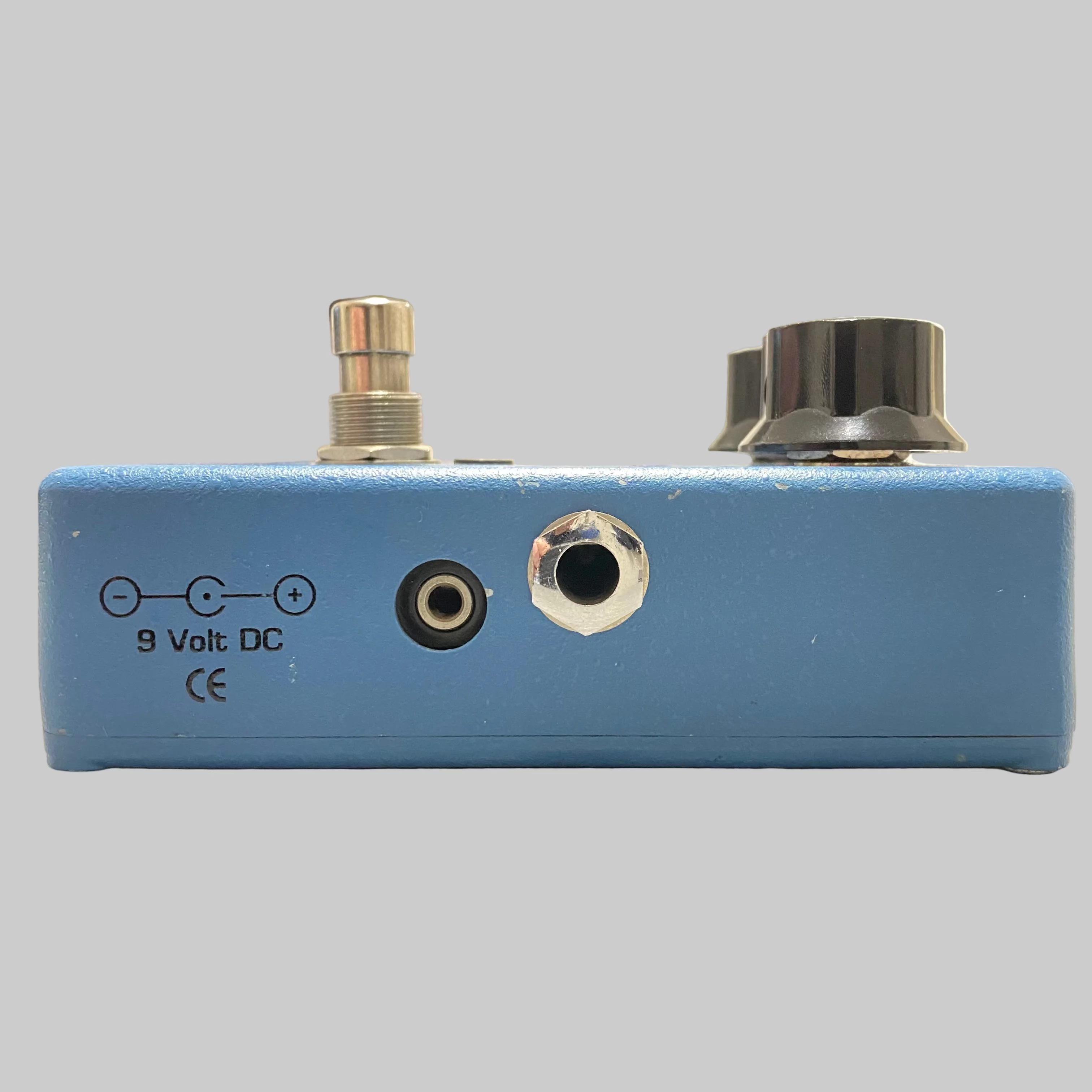 Blue electronic pedal with connectors on a desk