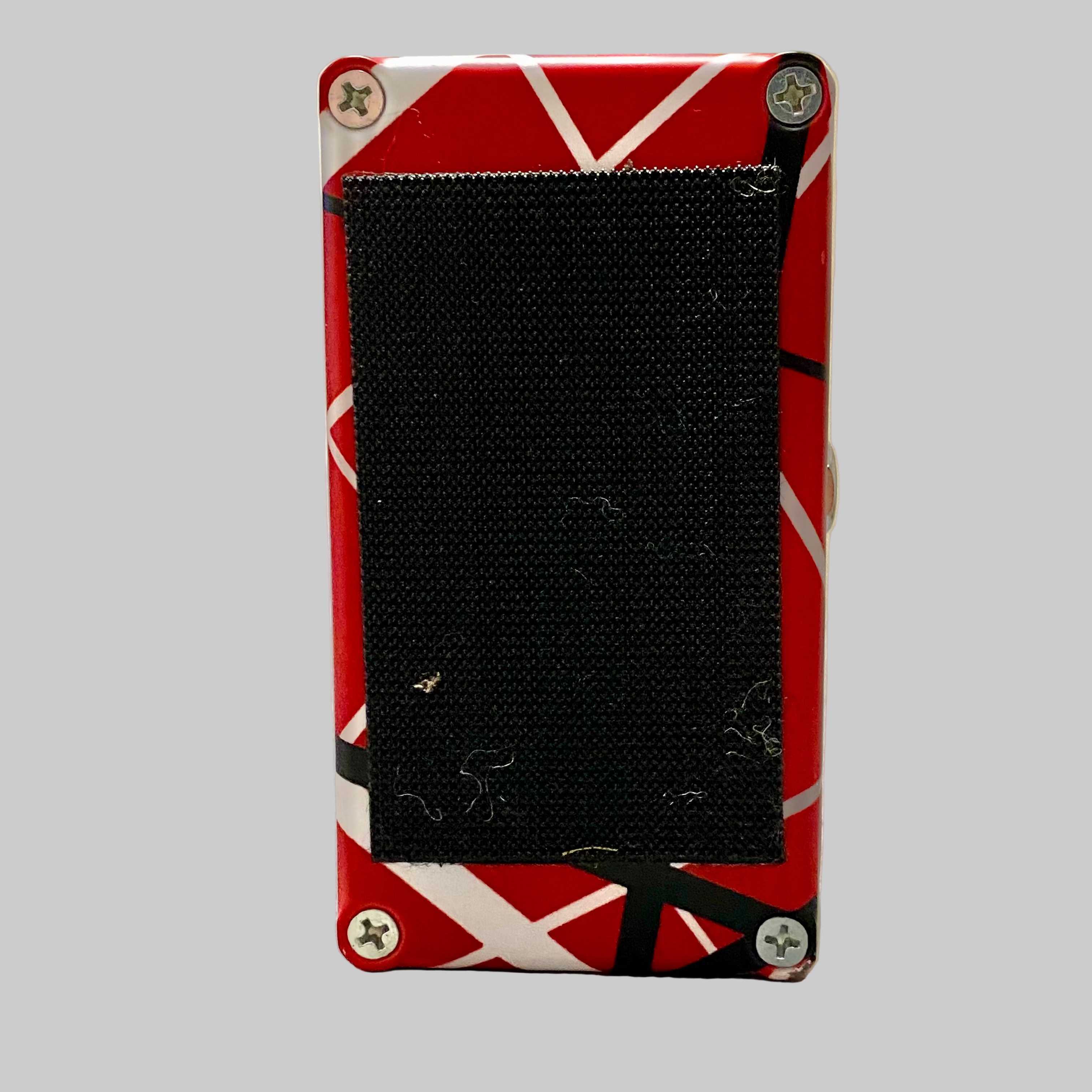 Red and white striped electronic device on a wooden surface