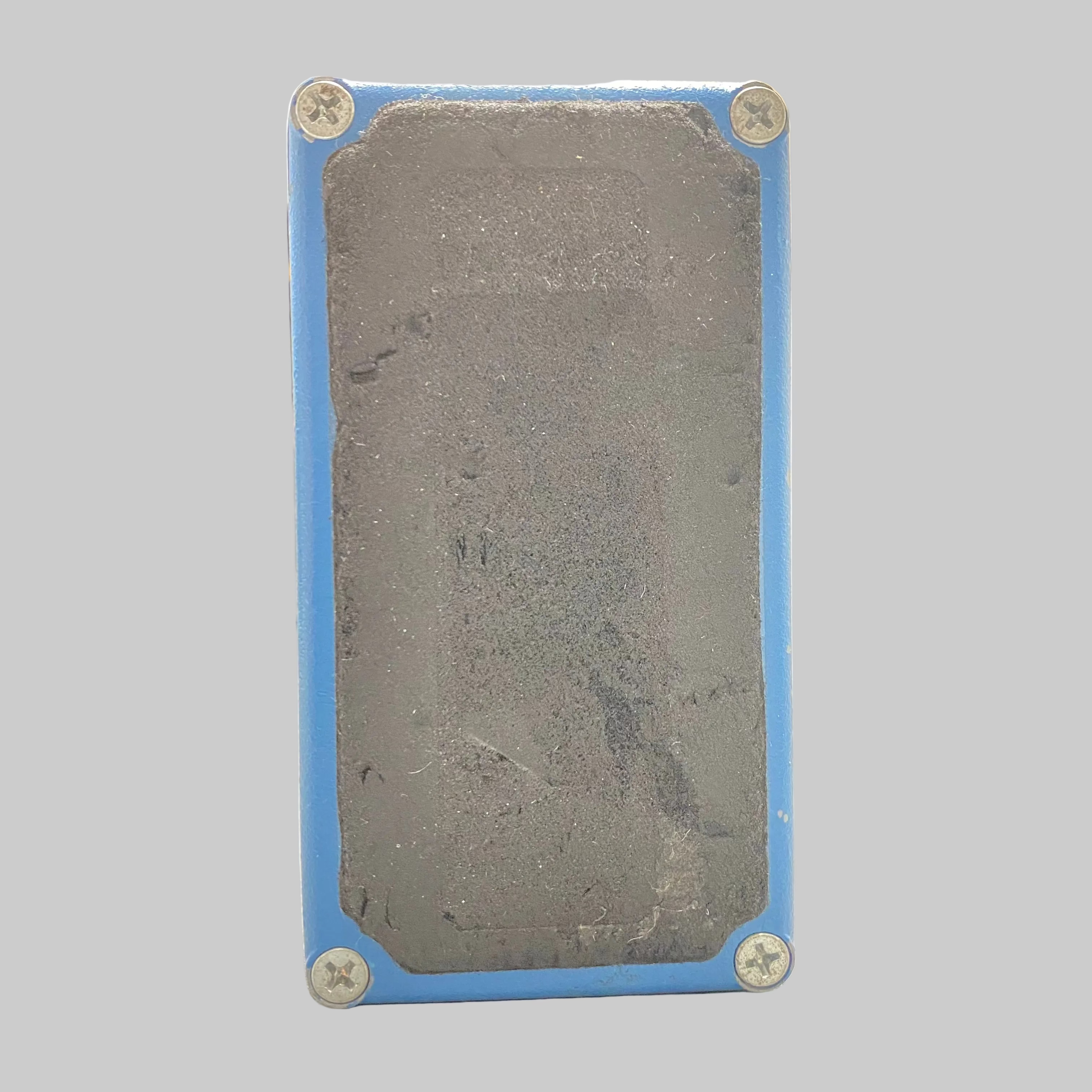Rectangular metal block with blue casing on a desk