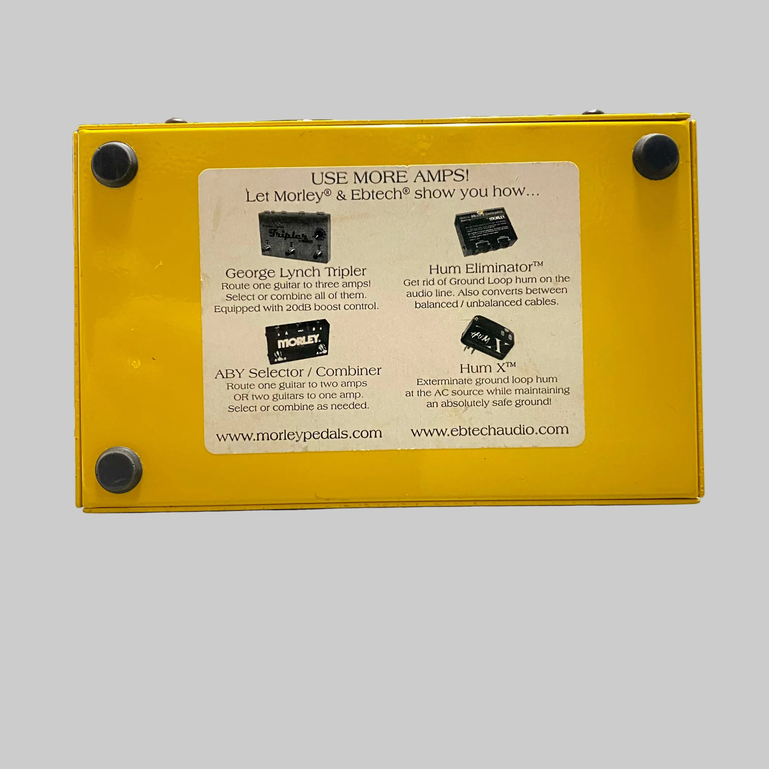 Yellow guitar effects pedal with text on a desk