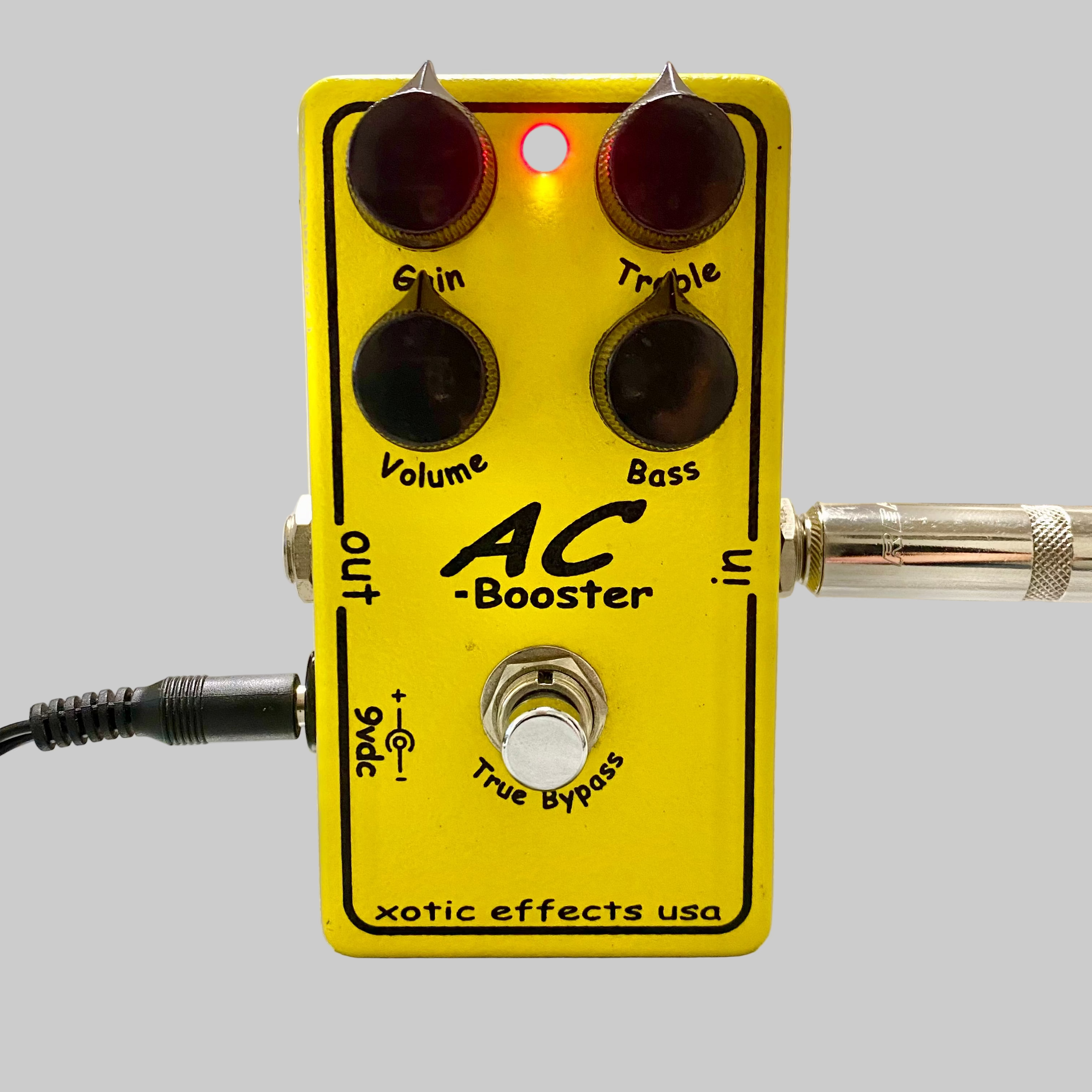 Yellow guitar effects pedal labeled 'AC Booster' on a table.