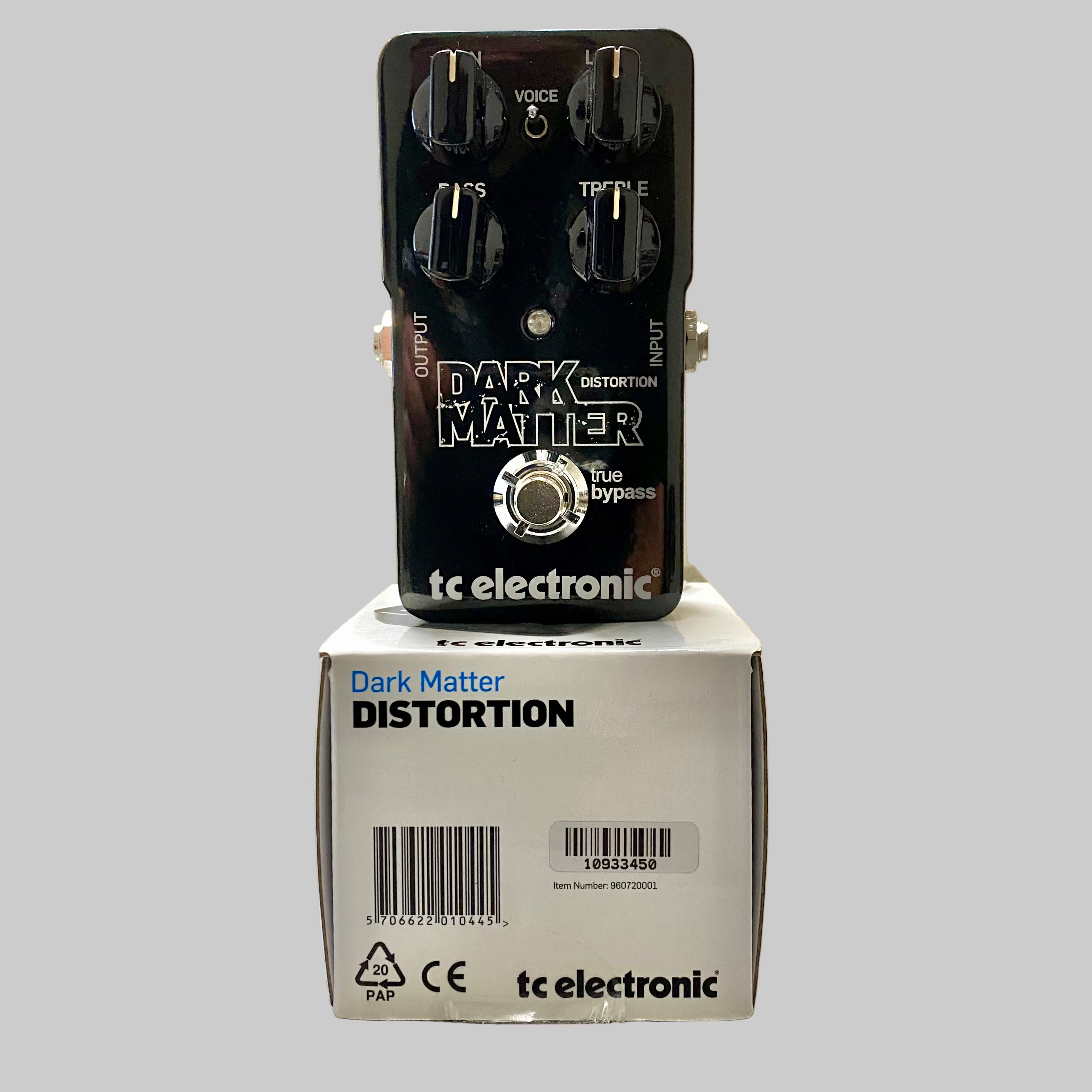 Guitar effects pedal 'Dark Matter Distortion' by tc electronic on top of its packaging box.