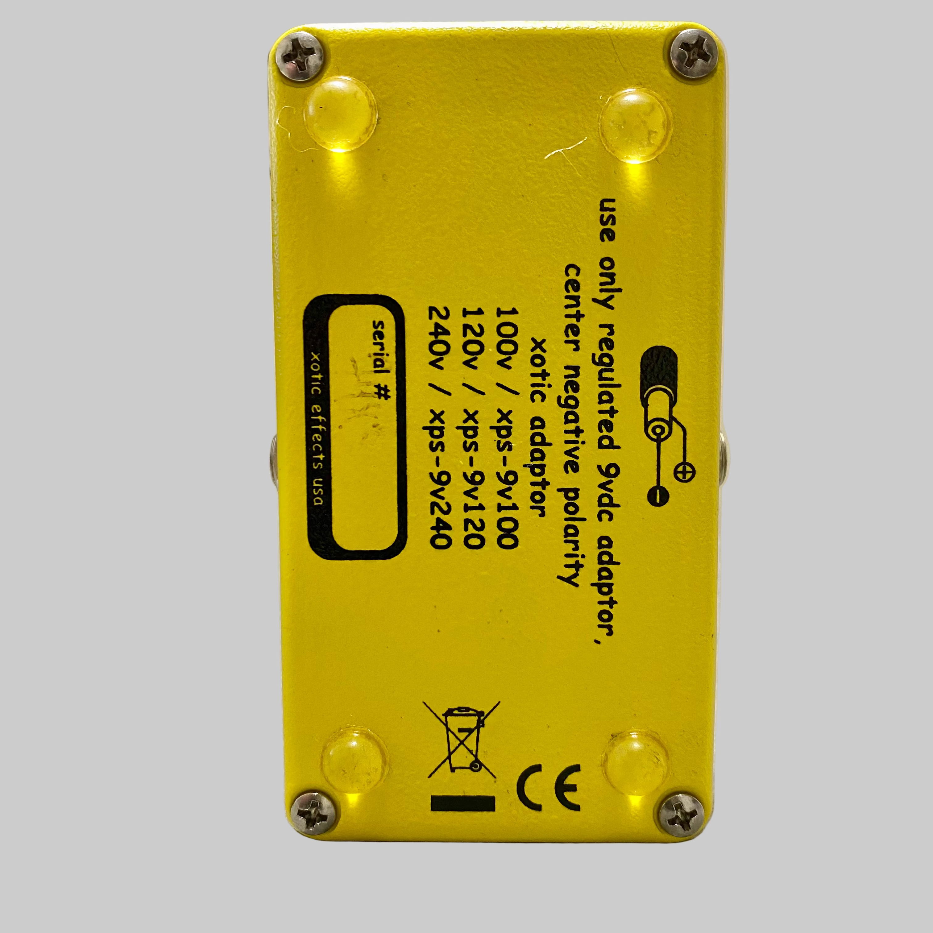 Yellow electronic device with text and symbols on a wooden surface