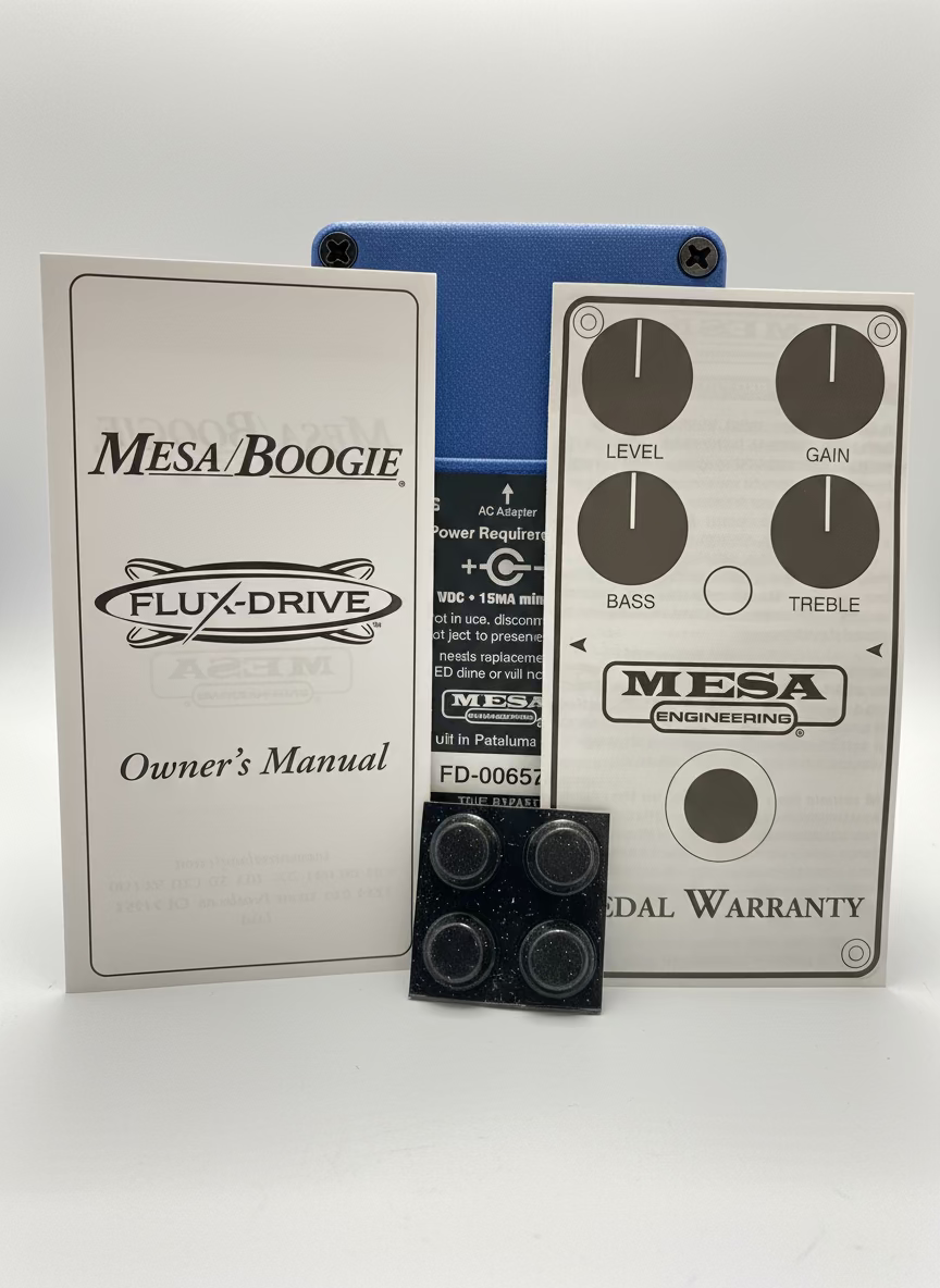 Mesa/Boogie Flux-Drive guitar effects pedal with owner's manual and warranty card on a table.