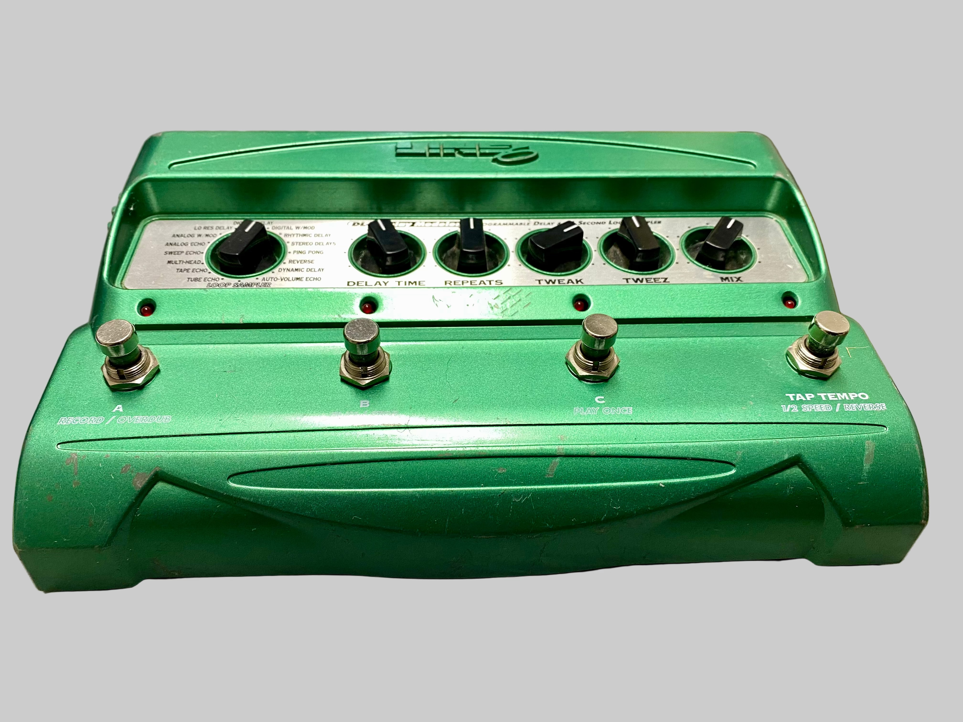Green guitar effects pedal on a wooden surface