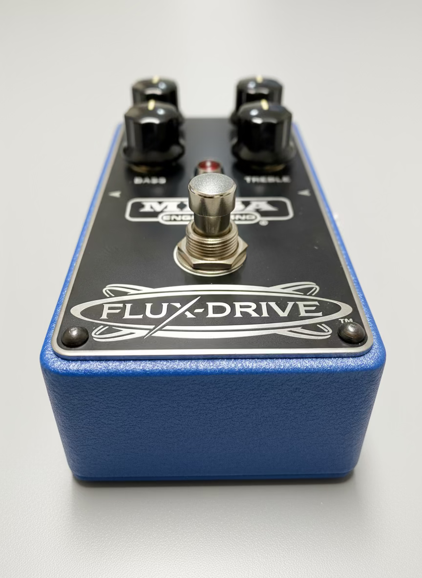 Guitar effects pedal with 'Flux-Drive' branding on a wooden surface