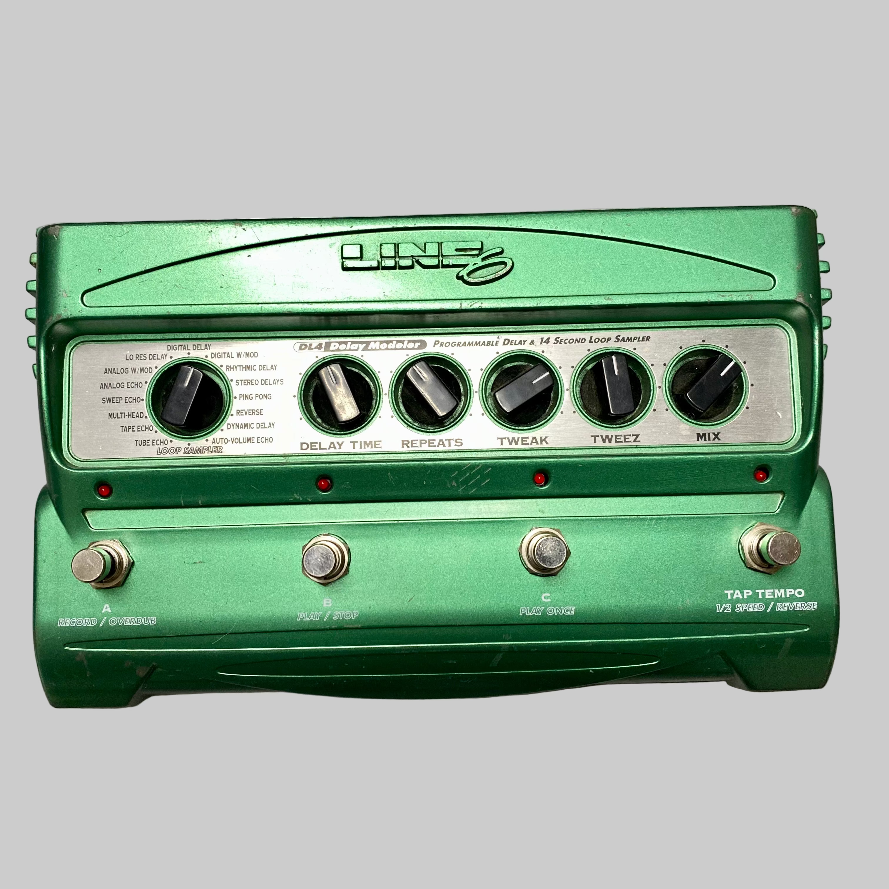 Green guitar effects pedal with visible brand name on a wooden surface