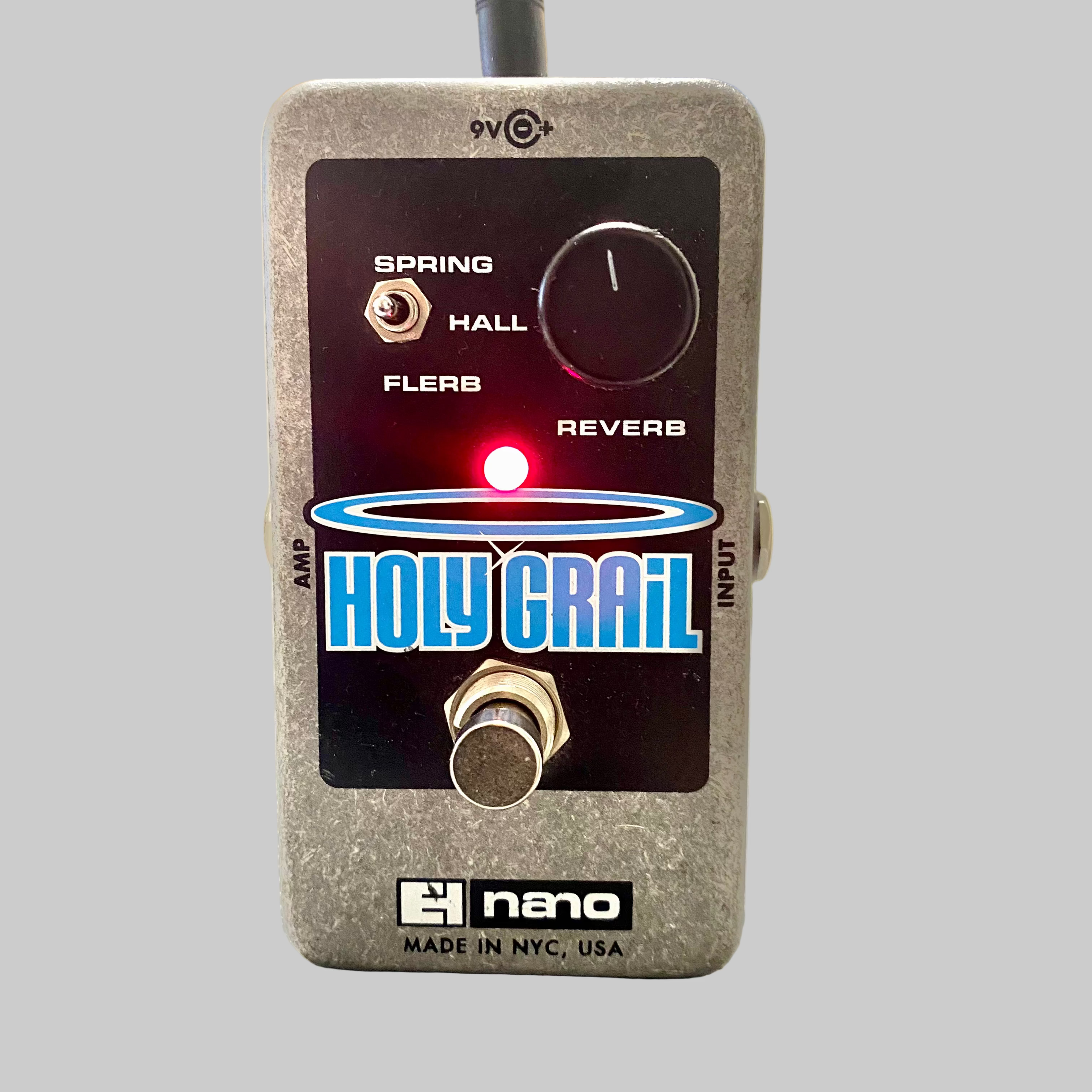 Guitar effects pedal with 'Holy Grail' branding on a wooden surface.
