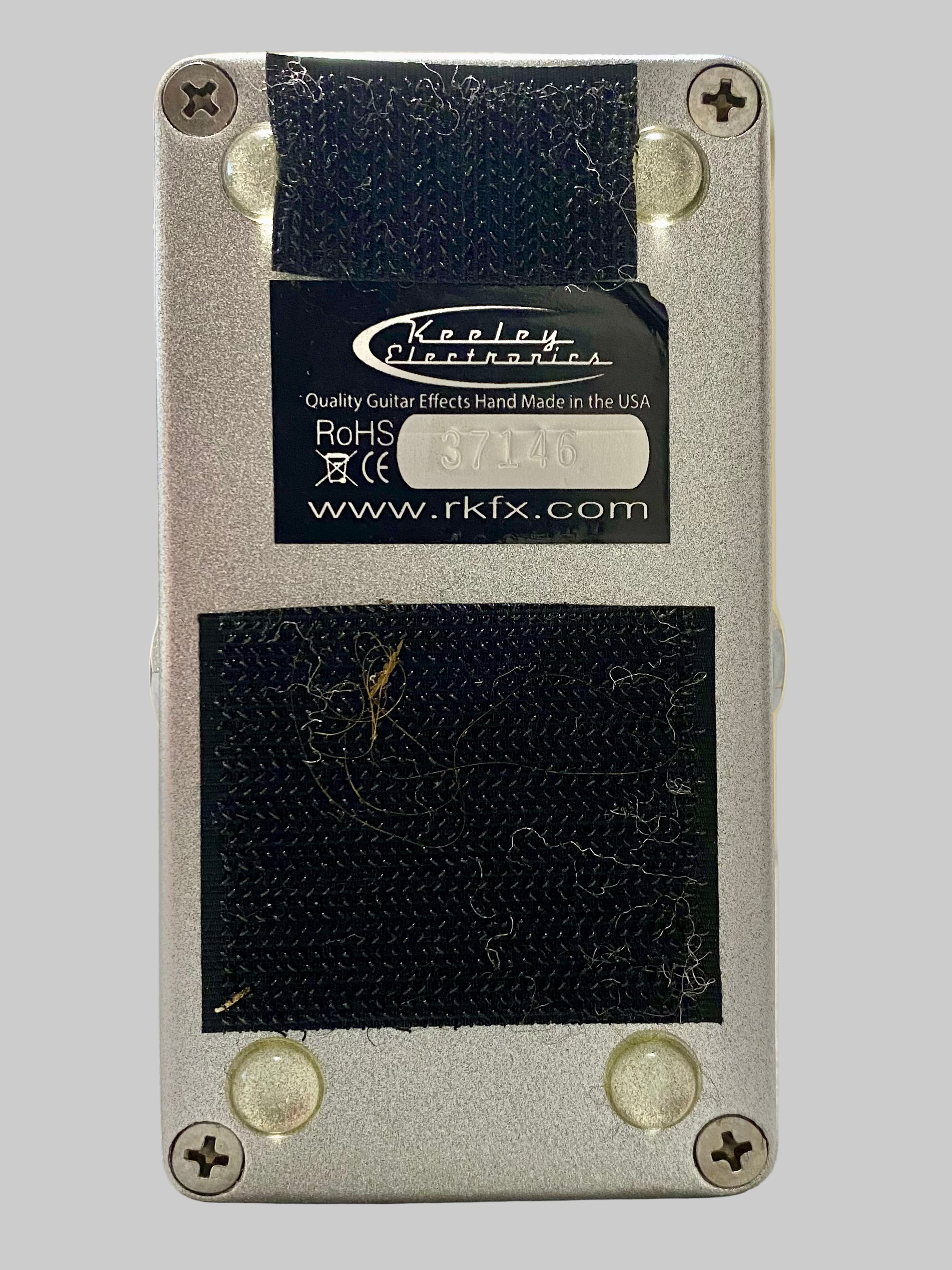 Guitar effects pedal with Klon Centaur branding on a wooden surface.