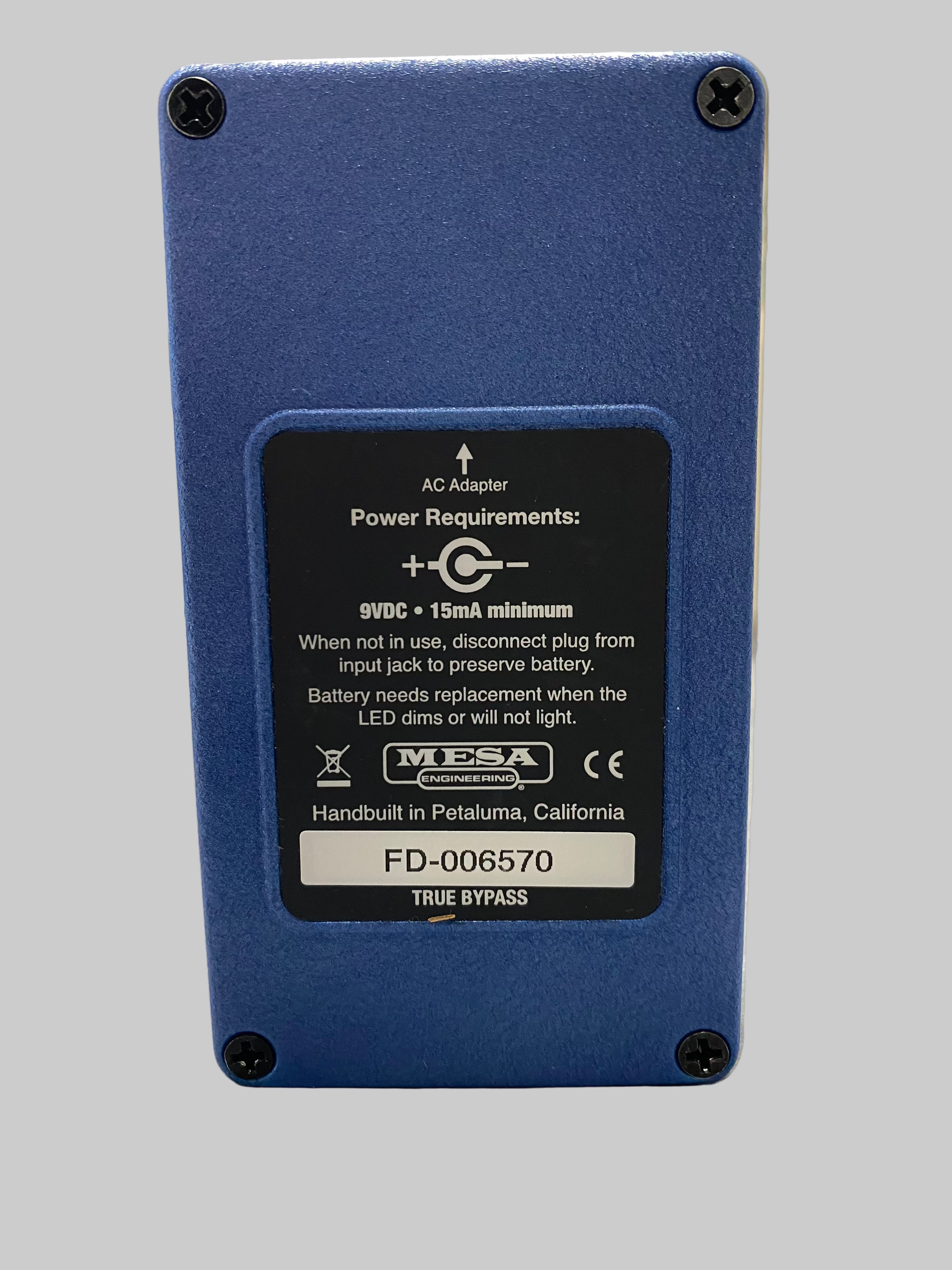 Blue electronic device with power requirements label on a light surface
