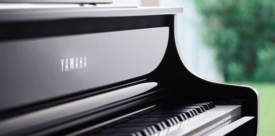 Yamaha piano with a blurred green outdoor background